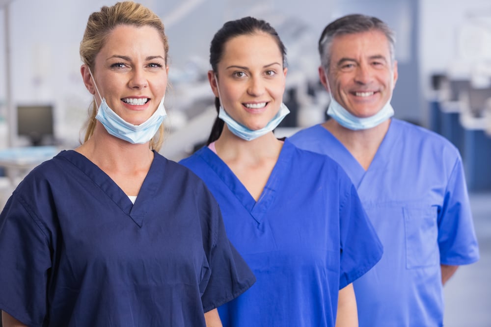 Portrait of smiling co-workers standing in a line in dental clinic-1